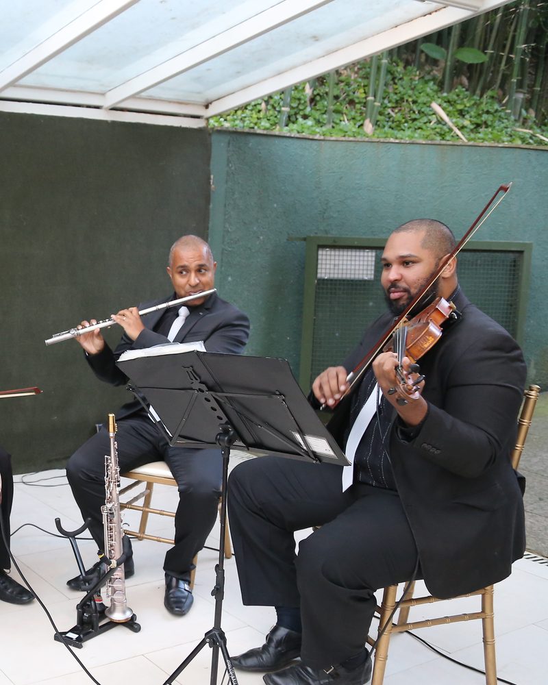Duo de flauta e violino tocando na cerimônia de um casamento ao ar livre